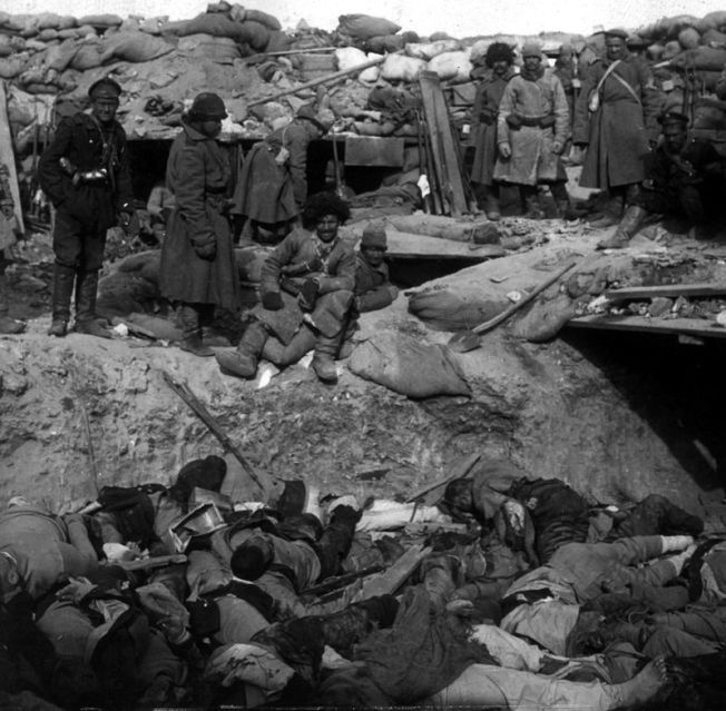 En una trinchera soldados rusos de pié y multitud de japoneses muertos.